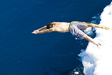 Guests from the Lindblad Expedition ship National Geographic Explorer take the Polar Plunge off ice floe in the Weddell Sea, Antarctica, Southern Ocean