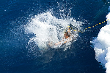 Guests from the Lindblad Expedition ship National Geographic Explorer take the Polar Plunge off ice floe in the Weddell Sea, Antarctica, Southern Ocean