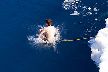 Guests from the Lindblad Expedition ship National Geographic Explorer take the Polar Plunge off ice floe in the Weddell Sea, Antarctica, Southern Ocean