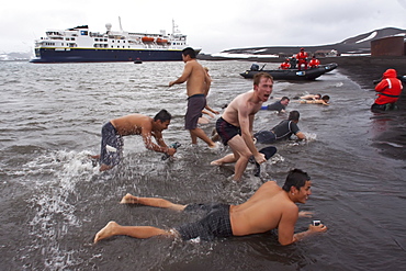 Guests from the Lindblad Expedition ship National Geographic Explorer lay in the relatively warm waters of the caldera at Deception Island, South Shetland Islands, Antarctica