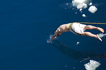 Guests from the Lindblad Expedition ship National Geographic Explorer take the Polar Plunge off ice floe in the Weddell Sea, Antarctica, Southern Ocean