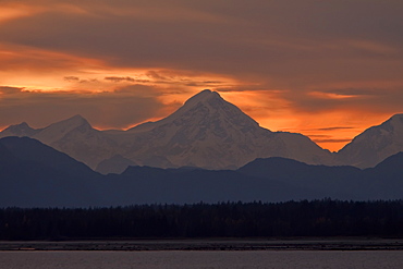 Sunset over the snow-capped mountains of the Fairweather Range across Icy Strait in Southeast Alaska, USA, Pacific Ocean.