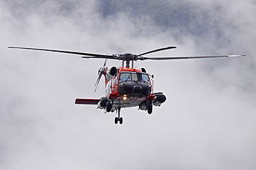 U.S. Coast Guard helicopter performing a rescue operation in Southeast Alaska, USA, Pacific Ocean.