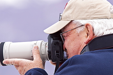 Guest from the Lindblad Expedition ship National Geographic Explorer taking photographs in the Svalbard Archipelago in the summer months