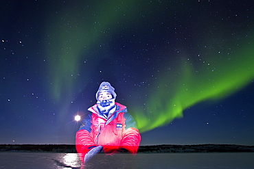 Self-portrait with aurora borealis (Northern (Polar) Lights) over the boreal forest outside Yellowknife, Northwest Territories, Canada