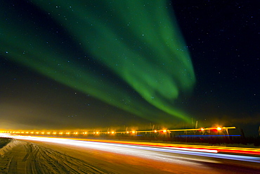 Aurora Borealis (Northern (Polar) Lights) with truckers lights on the ice road outside Yellowknife, Northwest Territories, Canada