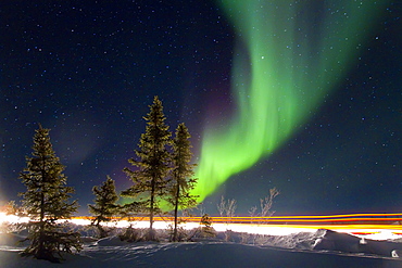 Aurora Borealis (Northern (Polar) Lights) with truckers lights on the ice road outside Yellowknife, Northwest Territories, Canada