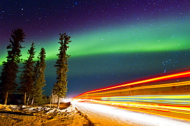 Aurora Borealis (Northern (Polar) Lights) with truckers lights on the ice road outside Yellowknife, Northwest Territories, Canada