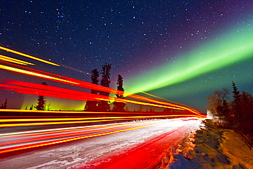 Aurora Borealis (Northern (Polar) Lights) with truckers lights on the ice road outside Yellowknife, Northwest Territories, Canada