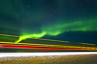 Aurora Borealis (Northern (Polar) Lights) with truckers lights on the ice road outside Yellowknife, Northwest Territories, Canada