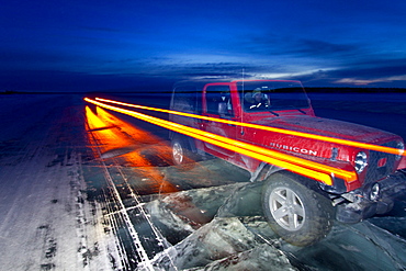 Long exposure camera times of a Jeep on the ice road from Tibbitt to Contwoyto beginning just outside of Yellowknife, Northwest Territories, Canada