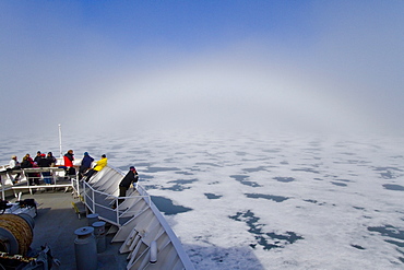 Fog and a fog bow surround the Lindblad Expeditions ship National Geographic Explorer in Palanderbutka, Nordaustlandet, in the Svalbard Archipelago, Norway