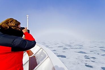 Fog and a fog bow surround the Lindblad Expeditions ship National Geographic Explorer in Palanderbutka, Nordaustlandet, in the Svalbard Archipelago, Norway