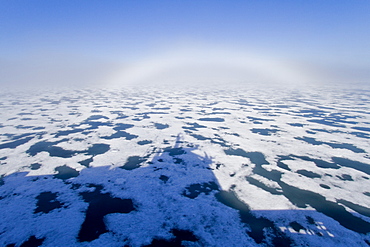 Fog and a fog bow surround the Lindblad Expeditions ship National Geographic Explorer in Palanderbutka, Nordaustlandet, in the Svalbard Archipelago, Norway