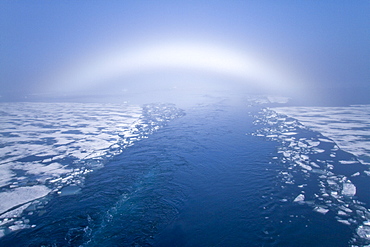 Fog and a fog bow surround the Lindblad Expeditions ship National Geographic Explorer in Palanderbutka, Nordaustlandet, in the Svalbard Archipelago, Norway