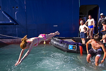 Guests from the Lindblad Expedition ship National Geographic Explorer taking the "polar plunge" in the Svalbard Archipelago, Norway