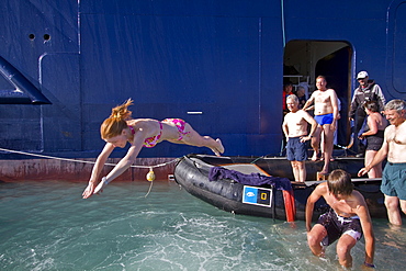 Guests from the Lindblad Expedition ship National Geographic Explorer taking the "polar plunge" in the Svalbard Archipelago, Norway