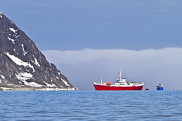 A view of the red expedition ship Antarctic Dream operating in the Svalbard Archipelago, Norway.