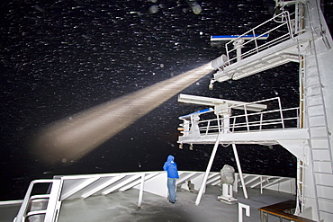 The Lindblad Expedition Ship National Geographic Explorer operating in gale-force winds and driving snow at night by spotlight in the Bransfield Strait, Antarctica