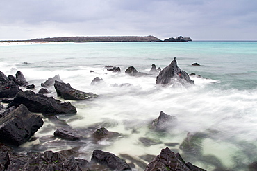 Surf breaking on lava shoreline at Gardner Bay on Espanola Island in the Galapagos Island Archipelago, Ecuador. MORE INFO Slow shutter speeds allow for surreal water movement in this photograph.