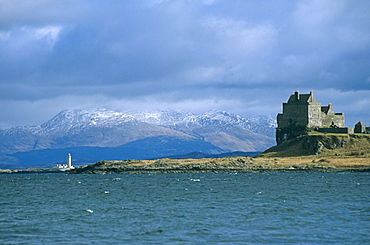 Duart Castle and the Lismore lighthouse.  the castle has been the home of the Clan Maclean since the 14th century. Isle of Mull, Scotland