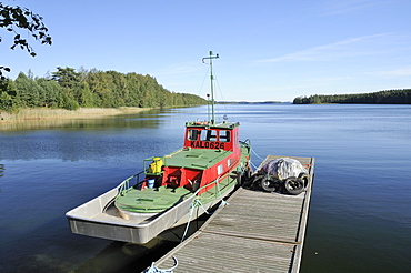 Boat moored at a jetty on Lake Puruvesi, a branch of Lake Saimaa near Kerimaki, Finland, Scandinavia, Europe