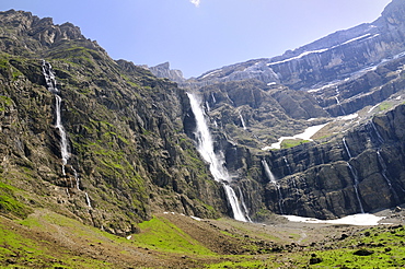 Waterfalls cascade down the karst limestone cliffs of the Cirque de Gavarnie, Pyrenees National Park, Hautes-Pyrenees, France, Europe