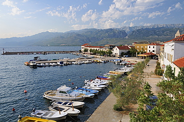 Overview of Vinjerac fishing  village and harbour with the karst limestone Velebit mountain range of the Dinaric Alps in the background, Zadar province, Croatia.