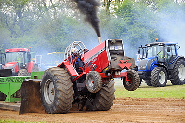 High powered tractor "Chain Reaction" competing in a tractor pull competition to drag a weighted sledge as far as possible, North Somerset Show, UK.