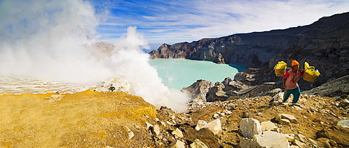 Panorama of sulphur worker appearing out of toxic fumes at Kawah Ijen volcano, East Java, Indonesia, Southeast Asia, Asia