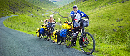 Cyclists on roadway through Wrynose Pass in the Dudden Valley part of the Lake District National Park, Cumbria, UK