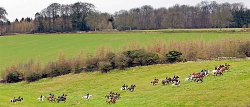 Huntsmen riding across fields during the Heythrop New Year's Day Hunt, Oxfordshire