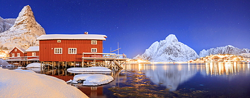 Panoramic view of snowy peaks and the frozen sea on a starry winter night, Reinevagen Bay, Nordland, Lofoten Islands, Arctic, Norway, Scandinavia, Europe