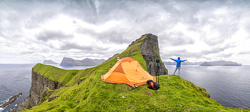 Panoramic of hiker and tent around Kallur Lighthouse, Kalsoy Island, Faroe Islands, Denmark, Europe