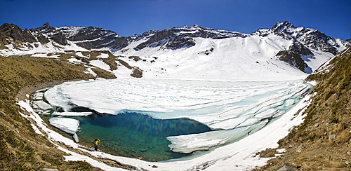 Photographer at Laj dal Teo where snow begins to melt due to spring thaw, Poschiavo Valley, Switzerland, Europe