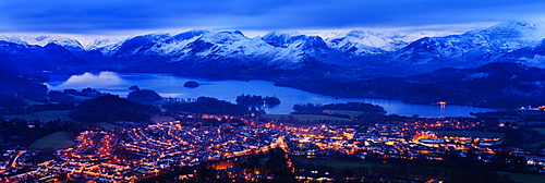 Looking over Keswick to Derwent Water and the snow capped mountains in the Lake District National Park at dusk, Cumbria, England, United Kingdom, Europe