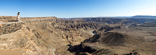 A woman looks into The Fish River Canyon in southern Namibia, Africa