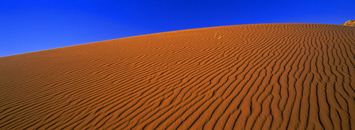 Panoramic view of orange sand dune and blue sky, Namib Rand, a 500000 acre private game reserve in the Namib Naukluft Park, Namibia, Africa