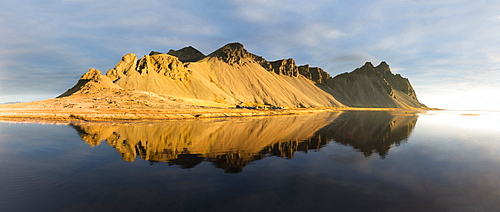 Panoramic view of mountains of Vestrahorn and perfect reflection in shallow water, soon after sunrise, Stokksnes, South Iceland, Polar Regions