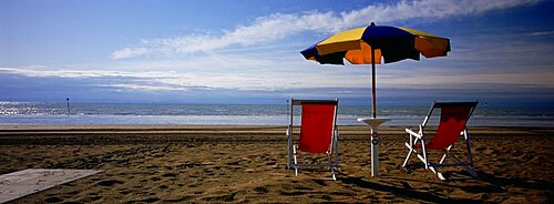 Two empty chairs under a beach umbrella, Lignano Sabbiadoro, Italy