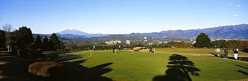 Group of people playing in a golf course with mountains in the background, Mt Fuji, Japan