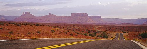 Highway passing through an arid landscape, Monument Valley Tribal Park, Arizona, USA