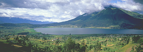 Imbabura Volcano, 4609 meters high above the waters of Laguna San Pablo with the fields around the town of Otavalo in the foreground, Highlands north of Quito, Ecuador