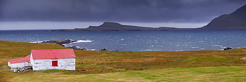 Red-roofed house in Stodvarfjordur fjord, East Fjords region (Austurland), Iceland, Polar Regions