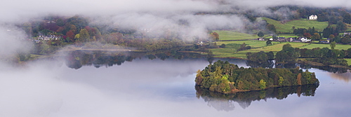 Grasmere lake and village appears through swirling morning mist, Lake District Narional Park, Cumbria, England, United Kingdom, Europe