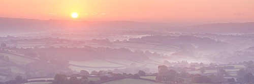 Sunrise over mist covered rolling countryside, Dartmoor, Devon, England, United Kingdom, Europe