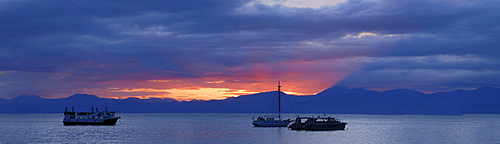 Sunrise behind boats at Kaiteriteri Beach, New Zealand