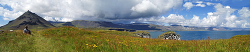 View over the bay of Arnarstapi and in the background the glacier SnÃŠfellsjokull SnÃŠfellsnes peninsula Iceland