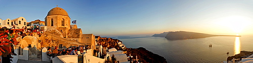 Tourists are waiting at the western part of the village for the sunset, Oia, Santorini, Greece