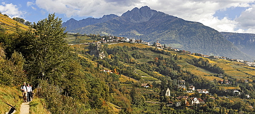 From the left the Algunder Waal (canal) hiking trail the Dorf Tirol below castle de Fontana and the mountain Ilfinger peak, near Meran, South Tyrol, Italy